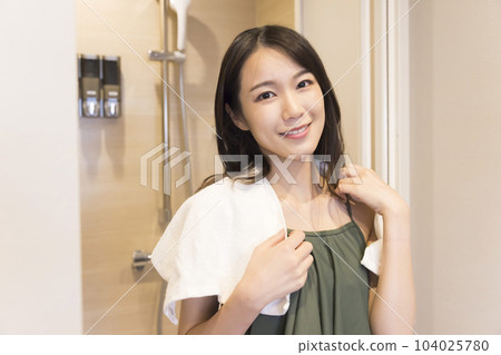 Young woman in swimsuit coming out of shower room after sauna 104025780