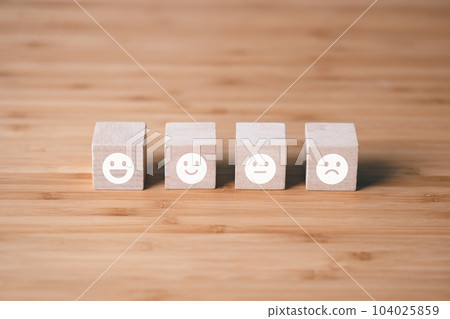 Wooden block of survey rating icon for customer satisfaction scores. customer satisfaction concept. Wooden block of survey rating icon for customer satisfaction scores. customer satisfaction concept. 104025859