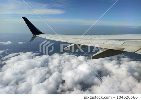 View through airplane window of commercial jet plane wing flying high in the sky. Air travelling concept View through airplane window of commercial jet plane wing flying high in the sky. Air travelling concept 104026560