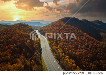 View from above of empty deserted I-40 freeway route in North Carolina leading to Asheville thru Appalachian mountains with yellow fall woods. Interstate transportation concept 104026597
