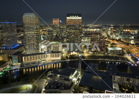 View from above of brightly illuminated high skyscraper buildings in downtown district of Tampa city in Florida, USA. American megapolis with business financial district at night 104026611