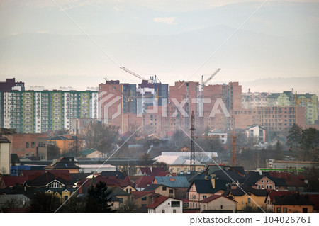Tower cranes at high residential apartment buildings construction site. Real estate development Tower cranes at high residential apartment buildings construction site. Real estate development 104026761