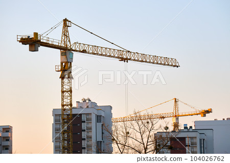Tower cranes at high residential apartment buildings construction site. Real estate development 104026762