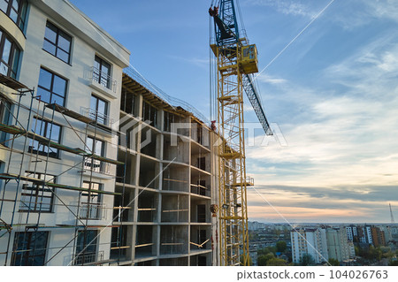 Tower cranes at high residential apartment buildings construction site. Real estate development Tower cranes at high residential apartment buildings construction site. Real estate development 104026763