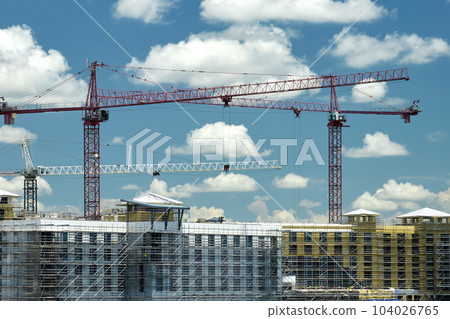 Tower cranes and frame structure of high residential apartment buildings at construction site. Real estate development 104026765
