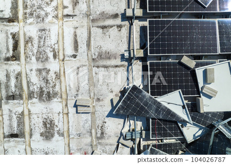 Top view of destroyed by hurricane Ian photovoltaic solar panels mounted on industrial building roof for producing green ecological electricity. Consequences of natural disaster in Florida Top view of destroyed by hurricane Ian photovoltaic solar panels mounted on industrial building roof for producing green ecological electricity. Consequences of natural disaster in Florida 104026787