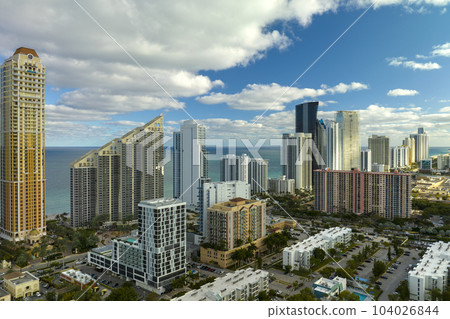 Sunny Isles Beach city with luxurious highrise hotels and condo buildings on Atlantic ocean shore. American tourism infrastructure in southern Florida 104026844