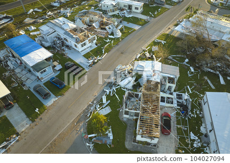 Severely damaged by hurricane Ian houses in Florida mobile home residential area. Consequences of natural disaster 104027094