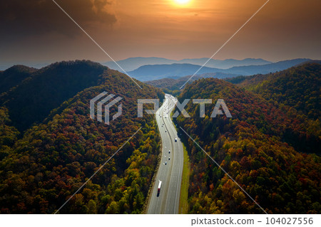I-40 freeway in North Carolina leading to Asheville through Appalachian mountains in golden fall with fast moving trucks and cars. Interstate transportation concept 104027556
