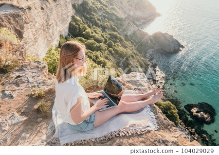 Woman sea laptop. Business woman working on laptop by sea at sunset. Close up on hands of pretty lady typing on computer outdoors summer day. Freelance, digital nomad, travel and holidays concept. Woman sea laptop. Business woman working on laptop by sea at sunset. Close up on hands of pretty lady typing on computer outdoors summer day. Freelance, digital nomad, travel and holidays concept. 104029029