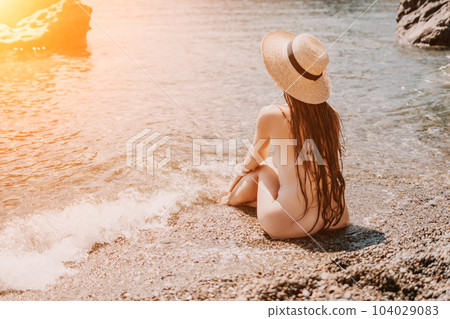 Woman travel sea. Happy tourist in hat enjoy taking picture outdoors for memories. Woman traveler posing on the beach at sea surrounded by volcanic mountains, sharing travel adventure journey Woman travel sea. Happy tourist in hat enjoy taking picture outdoors for memories. Woman traveler posing on the beach at sea surrounded by volcanic mountains, sharing travel adventure journey 104029083