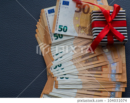 Gift box on the background of fifty euros banknotes Gift box on the background of fifty euros banknotes 104031074