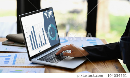 Closeup view female worker analyzing financial data and planning marketing strategy at office desk 104034561