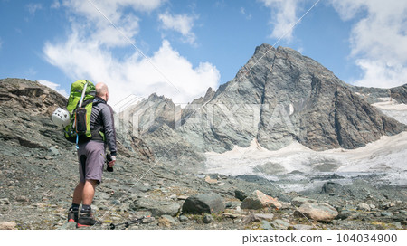 Mountaineer standing below a mountain he is about to climb, Austrian Alps, Europe Mountaineer standing below a mountain he is about to climb, Austrian Alps, Europe 104034900