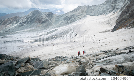 Mountaineers traversing a glacier in high alpine environment , Austrian Alps, Europe Mountaineers traversing a glacier in high alpine environment , Austrian Alps, Europe 104034904