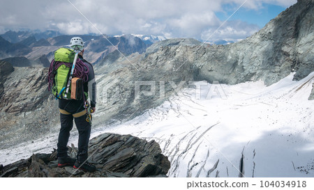 Mountaineer overlooking alpine landscape with glacier and rocky peaks, Austrian Alps, Europe Mountaineer overlooking alpine landscape with glacier and rocky peaks, Austrian Alps, Europe 104034918