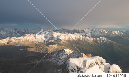 Majestic mountain range with peaks covered by snow during colorful sunset, Austrian Alps, Europe Majestic mountain range with peaks covered by snow during colorful sunset, Austrian Alps, Europe 104034936