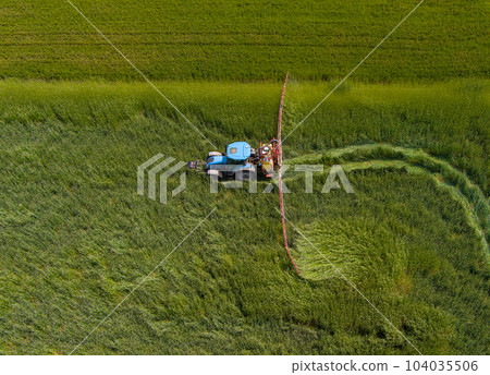 Tractor working on the agricultural field 104035506