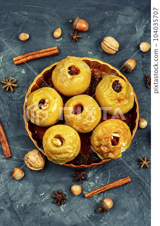 Baked autumn apples with nuts and raisins 104035707