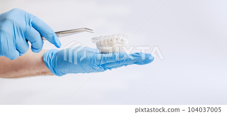 Orthodontic dental theme on blue background.Transparent invisible dental aligners or braces aplicable for an orthodontic dental treatment Orthodontic dental theme on blue background.Transparent invisible dental aligners or braces aplicable for an orthodontic dental treatment 104037005