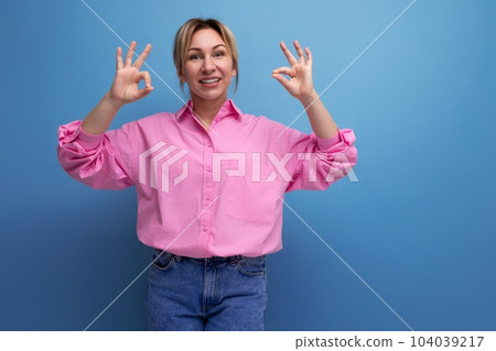 young well-groomed pretty european blonde secretary woman dressed in a pink shirt rejoices on a 104039217