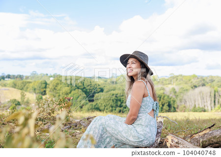 南美農民坐在牧場的樹樁上微笑 104040748