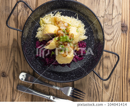 dumpllings filled with smoked meat served with red and white cabbage 104041414