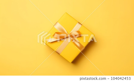 One yellow gift box in craft wrapping paper and satin ribbon with bow on yellow clean flat surface background, neural network generated image 104042453