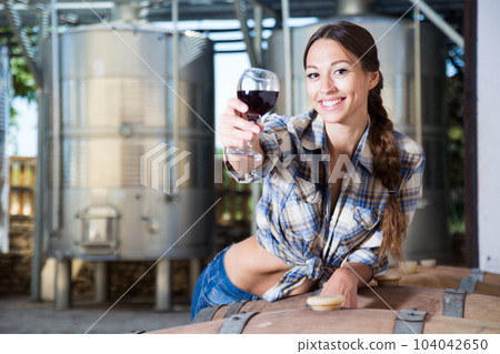 woman with glass of wine posing on the winery of spain 104042650