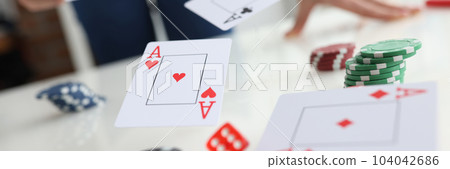 Poker player throws ace cards and casino chips Poker player throws ace cards and casino chips 104042686