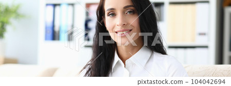 Beautiful smiling woman is reading book in living room Beautiful smiling woman is reading book in living room 104042694