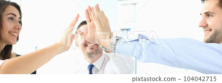 Happy business team high five in office Happy business team high five in office 104042715