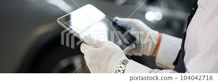 Male master locksmith holds tablet and performs car diagnostics Male master locksmith holds tablet and performs car diagnostics 104042716