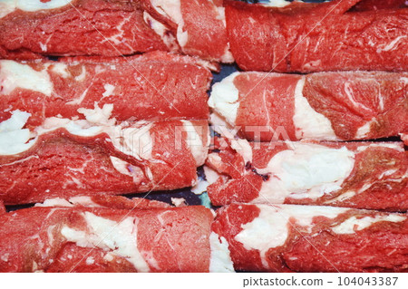 raw frozen beef meat slice roll ingredient food on plastic tray in white background raw frozen beef meat slice roll ingredient food on plastic tray in white background 104043387