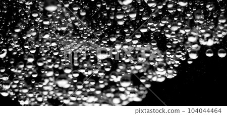Soda water bubbles splashing underwater against black background. Cola liquid texture that fizzing and floating up to surface like a explosion in under water for refreshing carbonate drink concept. 104044464