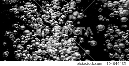 Soda water bubbles splashing underwater against black background. Cola liquid texture that fizzing and floating up to surface like a explosion in under water for refreshing carbonate drink concept. Soda water bubbles splashing underwater against black background. Cola liquid texture that fizzing and floating up to surface like a explosion in under water for refreshing carbonate drink concept. 104044485