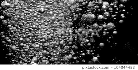 Soda water bubbles splashing underwater against black background. Cola liquid texture that fizzing and floating up to surface like a explosion in under water for refreshing carbonate drink concept. Soda water bubbles splashing underwater against black background. Cola liquid texture that fizzing and floating up to surface like a explosion in under water for refreshing carbonate drink concept. 104044488