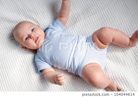 Portrait of Newborn. Beautiful Baby Face Close up. Small Child smiles and laughs. Cute little Baby is looking into the Camera. Newborn Health. Infancy, Childhood, and Health Concept Portrait of Newborn. Beautiful Baby Face Close up. Small Child smiles and laughs. Cute little Baby is looking into the Camera. Newborn Health. Infancy, Childhood, and Health Concept 104044614