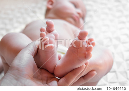 Mother holding Baby Feet in Hands. Legs Newborn in female parents Hand. Small children's Feet in the Mom Palm. Close-up. Little Toes of Child and Woman Hands of Happy Parent. Mother's Day Holiday Mother holding Baby Feet in Hands. Legs Newborn in female parents Hand. Small children's Feet in the Mom Palm. Close-up. Little Toes of Child and Woman Hands of Happy Parent. Mother's Day Holiday 104044630