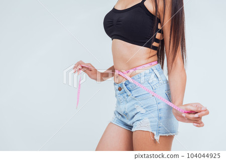Healthy slimming woman body care measuring waist fat with line tape measure or measuring tape. Healthy slimming woman body care measuring waist fat with line tape measure or measuring tape. 104044925