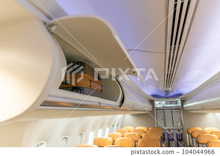 In flight carry on bag cabinet, on board suitcase storage overhead bin in passenger cabin crew. 104044966