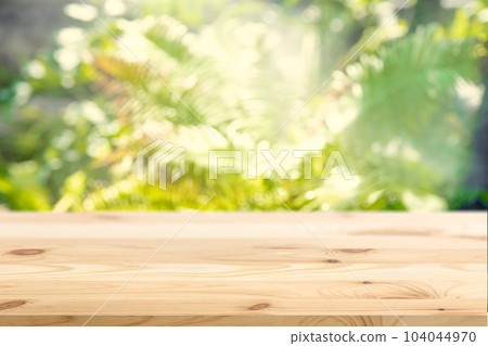 Blur Green Plant Garden Nature with Empty Wooden Floor Foreground for Eco Products Advertising Montage Background. 104044970