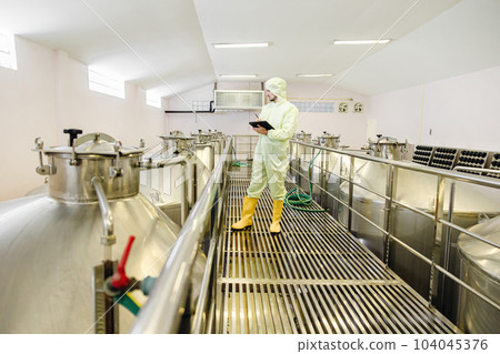 Brewery beverage factory worker working check fermentation tank with clean and hygiene cover suit. 104045376