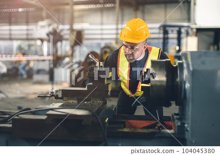 young engineer male worker work in heavy metal industry CNC lathe machine with safety young engineer male worker work in heavy metal industry CNC lathe machine with safety 104045380
