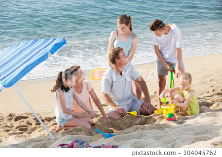Parents with four children playing 104045762
