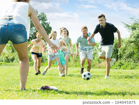 Young family with four kids running after ball Young family with four kids running after ball 104045875