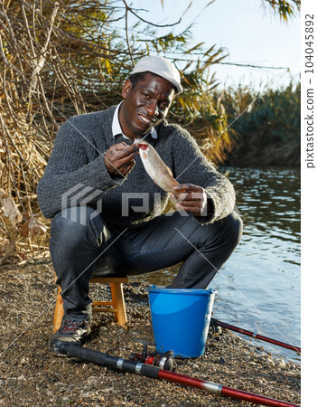 Fisherman holding fish in his hands 104045892
