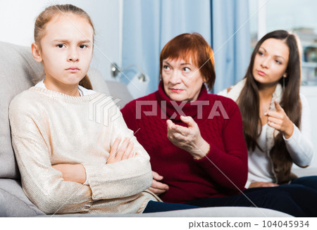Offended little while mom and granny scolding her Offended little while mom and granny scolding her 104045934