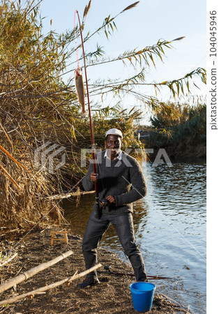 Man pulling fish on hook Man pulling fish on hook 104045946