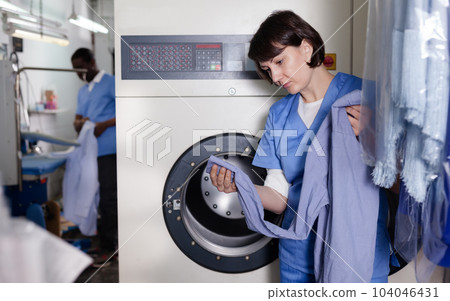 Female worker inspecting garments Female worker inspecting garments 104046431